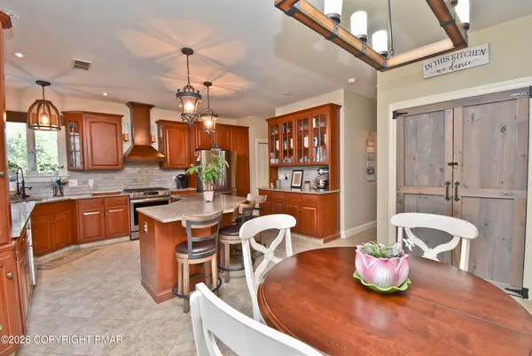 a kitchen with stainless steel appliances granite countertop a sink a stove and cabinets