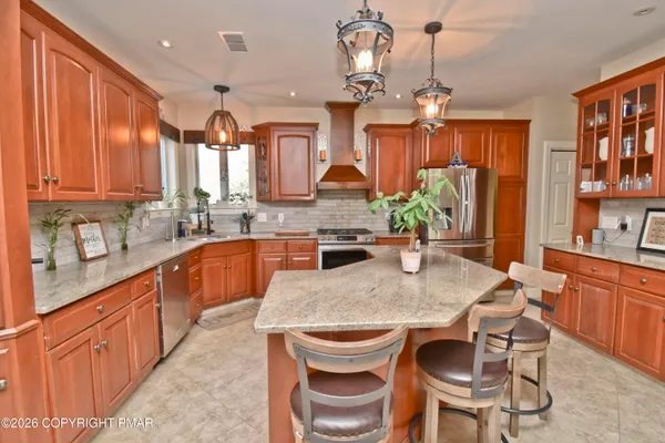 a kitchen with stainless steel appliances granite countertop a stove top oven a sink dishwasher and cabinets with wooden floor