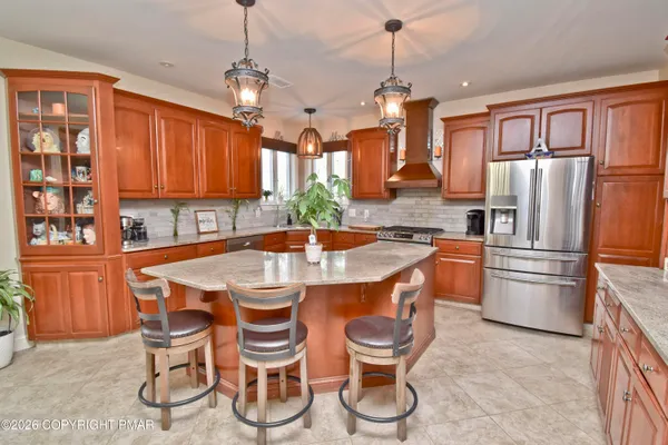 a kitchen with stainless steel appliances granite countertop a stove a sink dishwasher and cabinets with wooden floor