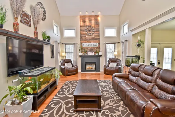 a living room with furniture a flat screen tv and kitchen view