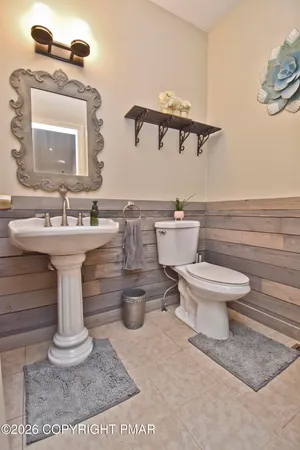 a bathroom with a sink a toilet a mirror and shower