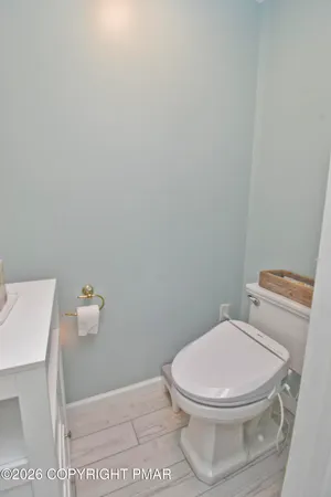 a spacious bathroom with a toilet a double vanity sink and a mirror