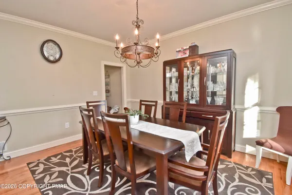 a dining room with furniture a kitchen and chandelier