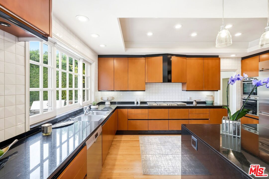 13019 Addison Street Sherman Oaks, CA 91423 - Photo 9 of 28 a large kitchen with stainless steel appliances granite countertop sink stove and large window
