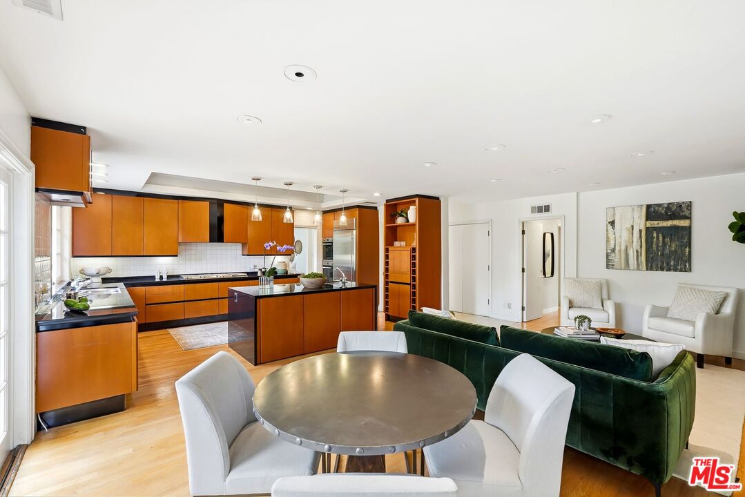 13019 Addison Street Sherman Oaks, CA 91423 - Photo 10 of 28 a kitchen with stainless steel appliances granite countertop a table and chairs