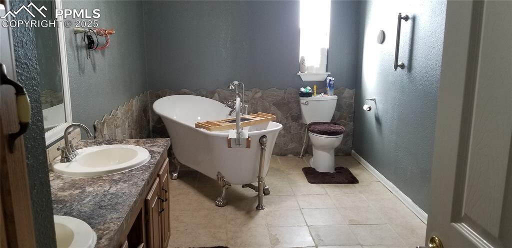610 Awesome View Yoder, CO 80864 - Photo 35 of 43 a bathroom with a granite countertop toilet a sink and mirror