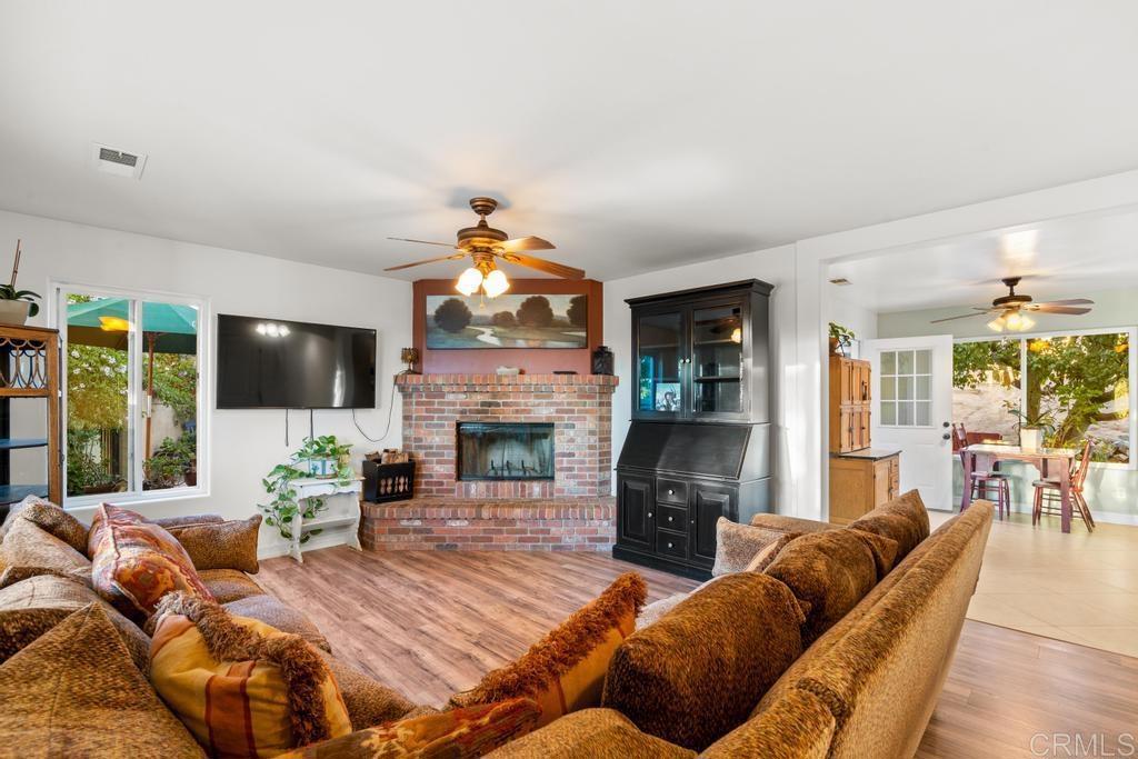 2043 Pamo Road Ramona, CA 92065 - Photo 15 of 63 a living room with furniture a flat screen tv and a fireplace