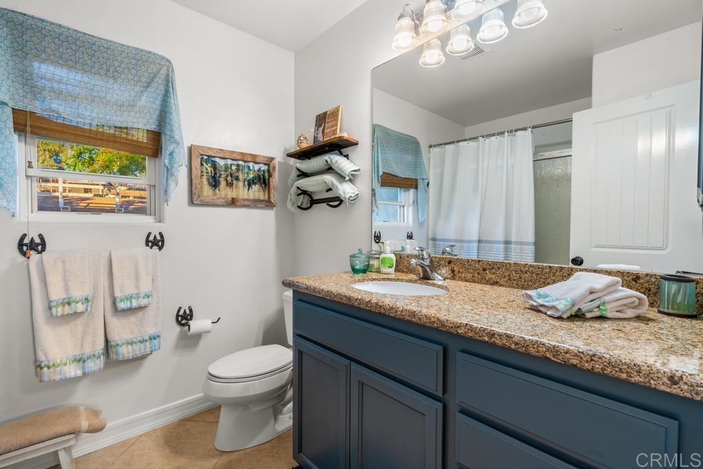 2043 Pamo Road Ramona, CA 92065 - Photo 23 of 63 a bathroom with a granite countertop sink mirror vanity and toilet