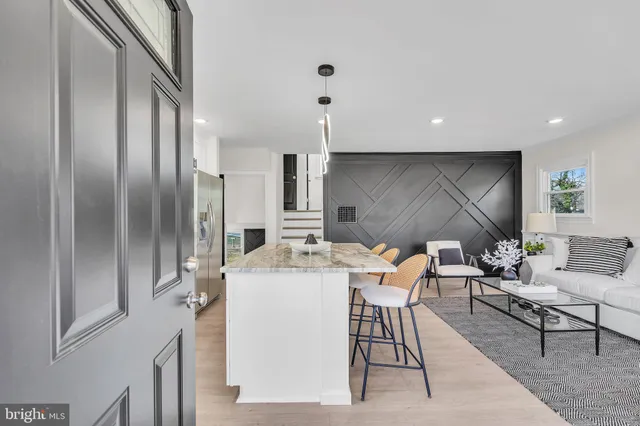 a kitchen with stainless steel appliances granite countertop a refrigerator a stove a sink a dining table and chairs