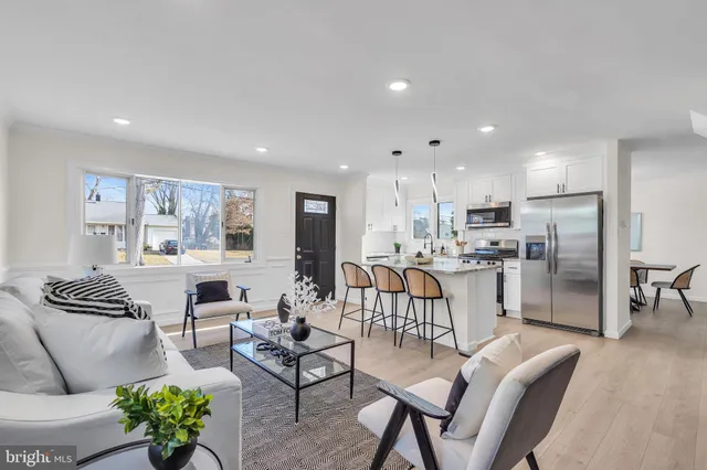 a kitchen with refrigerator a stove a sink and chairs