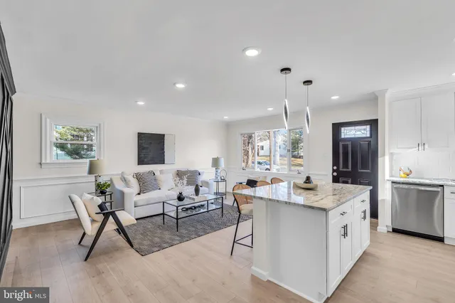 a kitchen with stainless steel appliances kitchen island granite countertop a sink stove and refrigerator