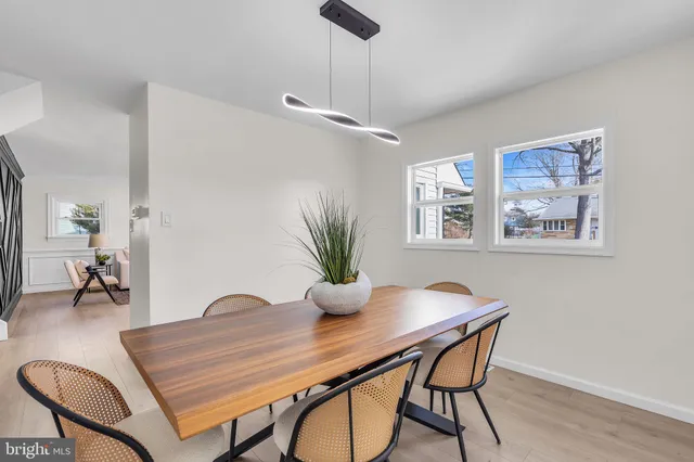 a kitchen with stainless steel appliances kitchen island granite countertop a dining table chairs refrigerator sink and cabinets