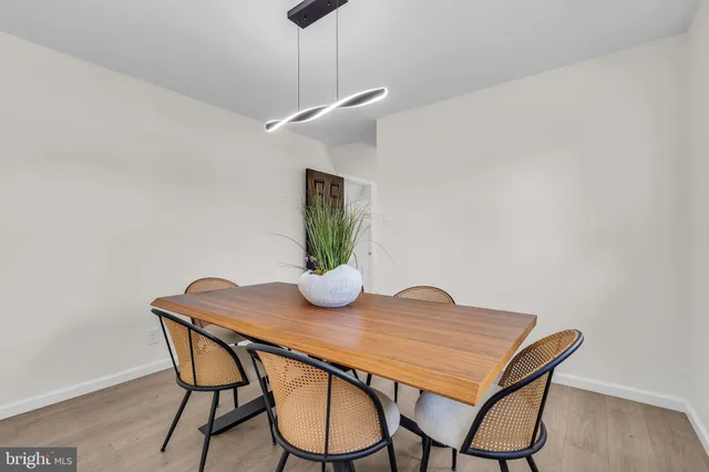 a kitchen with stainless steel appliances kitchen island granite countertop a stove a sink a refrigerator and white cabinets with wooden floor