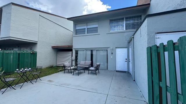 a view of a patio with table and chairs under an umbrella