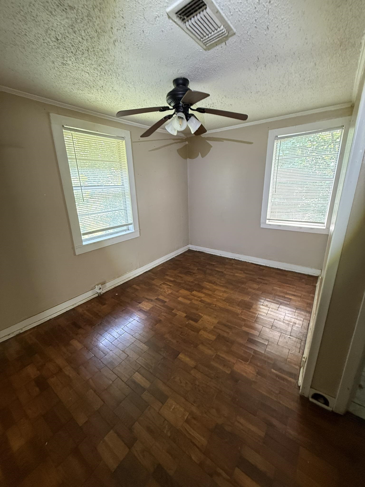 7503 Walsh Road Millington, TN 38053 - Photo 6 of 27 Bright corner bedroom with dual windows offering natural light, wood-finish flooring, ceiling fan with integrated lighting, and neutral wall finishes