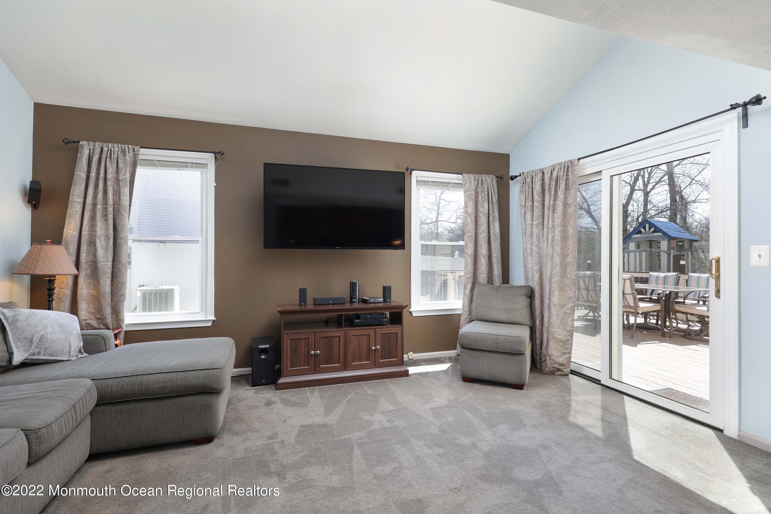 8 Reed Road Howell, NJ 07731 - Photo 12 of 22 a living room with furniture a flat screen tv and large windows