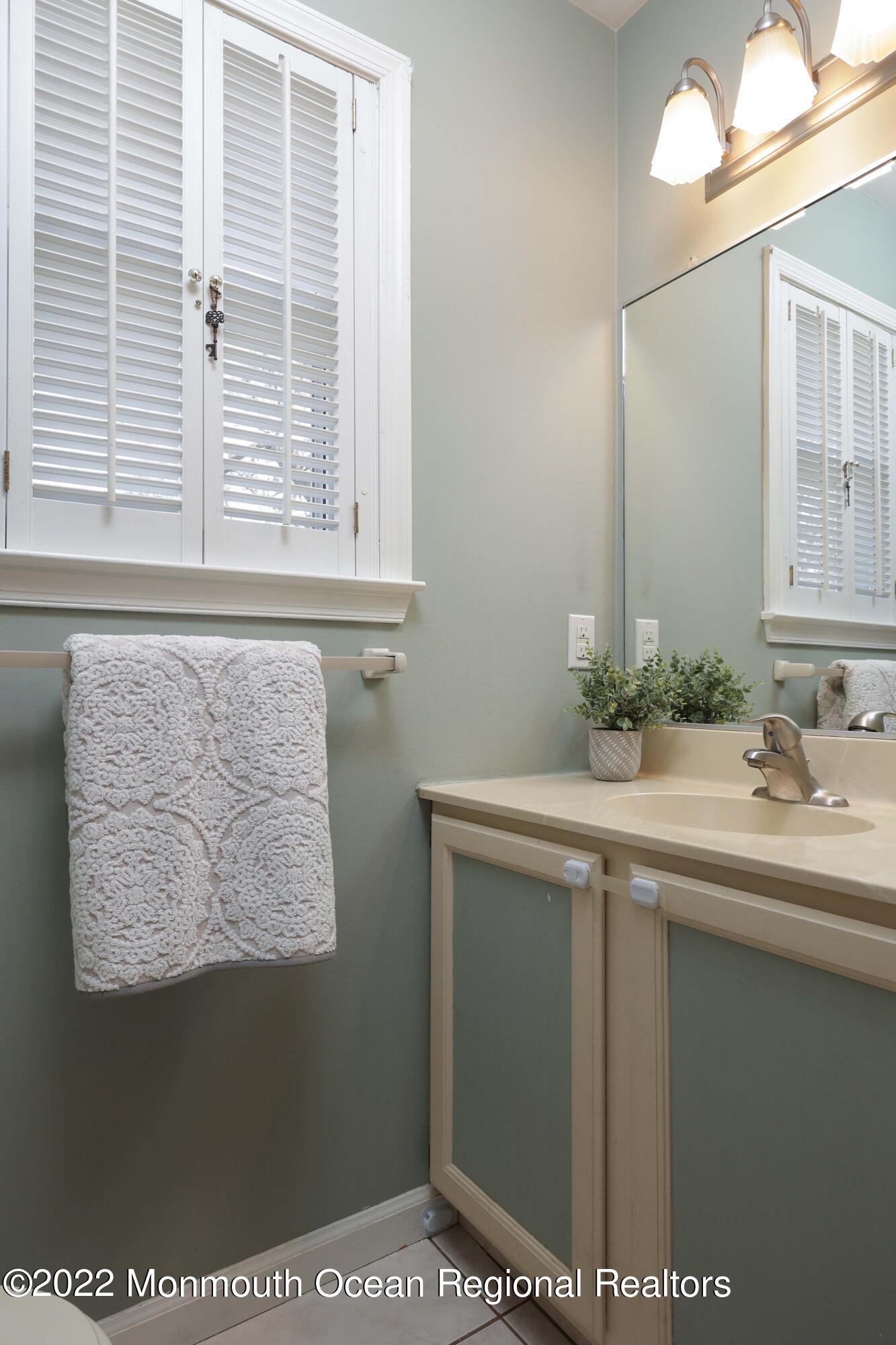 8 Reed Road Howell, NJ 07731 - Photo 5 of 22 a bathroom with a sink and a mirror