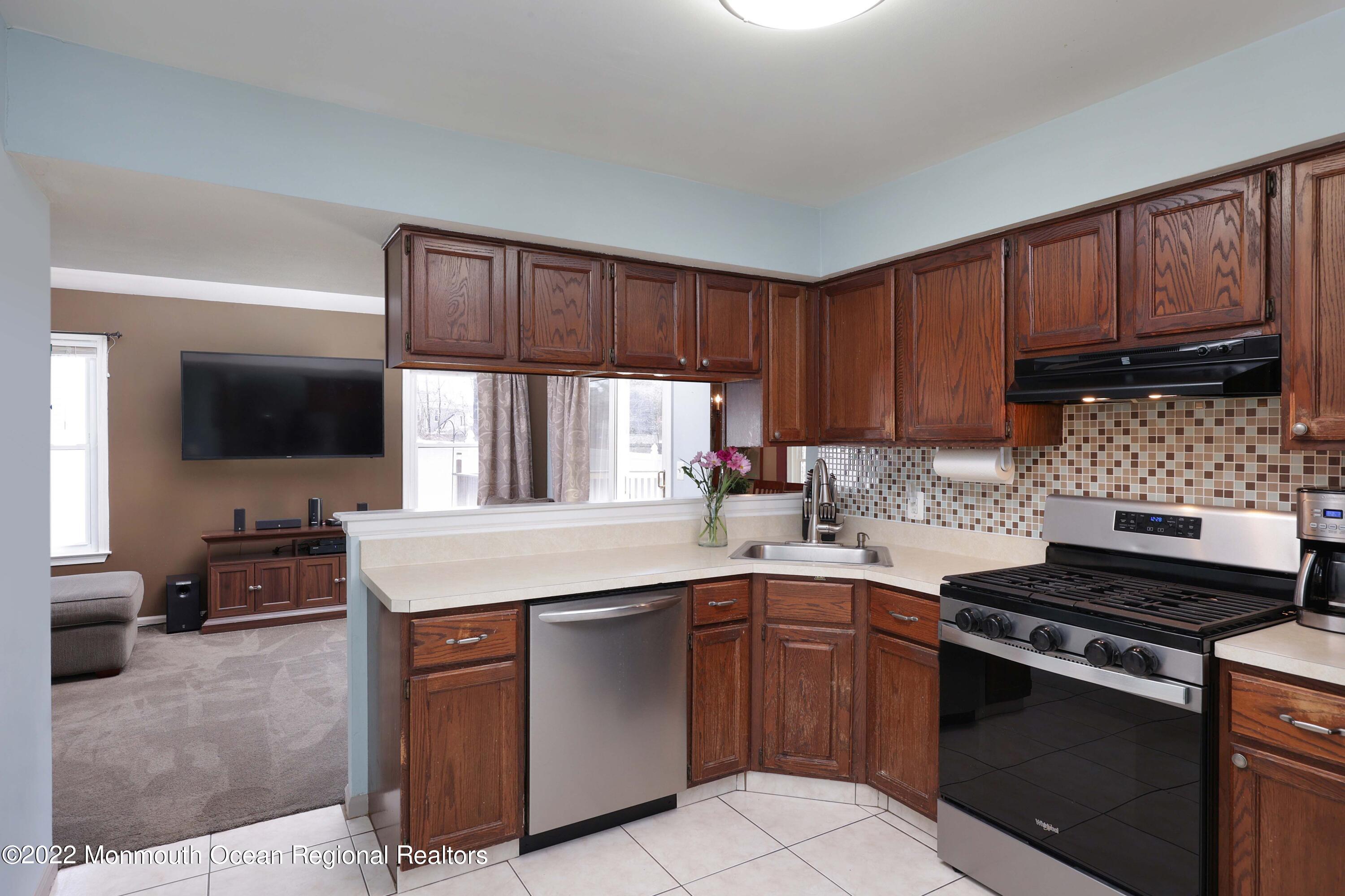 8 Reed Road Howell, NJ 07731 - Photo 9 of 22 a kitchen with a sink stove top oven and cabinets