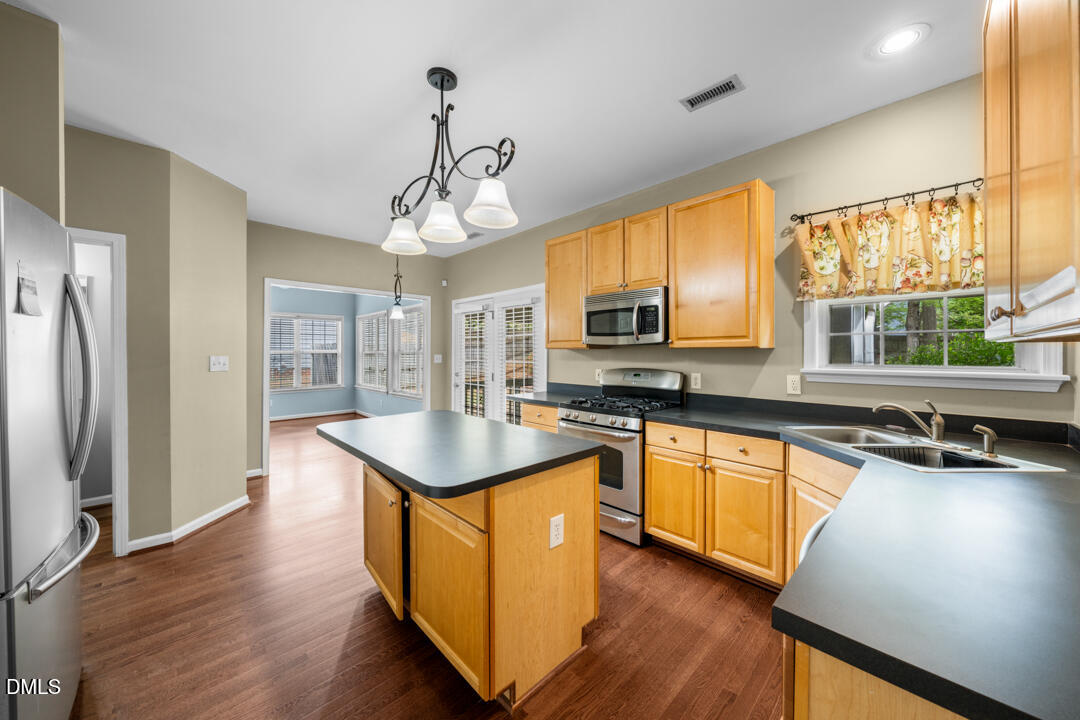 5324 Bartram Place Raleigh, NC 27617 - Photo 11 of 35 a kitchen with stainless steel appliances granite countertop a sink stove and refrigerator