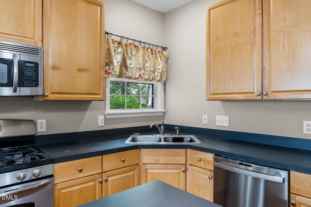 5324 Bartram Place Raleigh, NC 27617 - Photo 15 of 35 a kitchen with stainless steel appliances white cabinets and a window