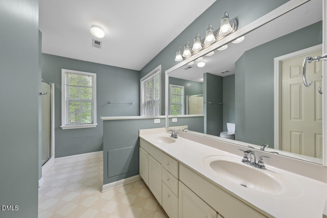 5324 Bartram Place Raleigh, NC 27617 - Photo 21 of 35 a spacious bathroom with a double vanity sink and a mirror