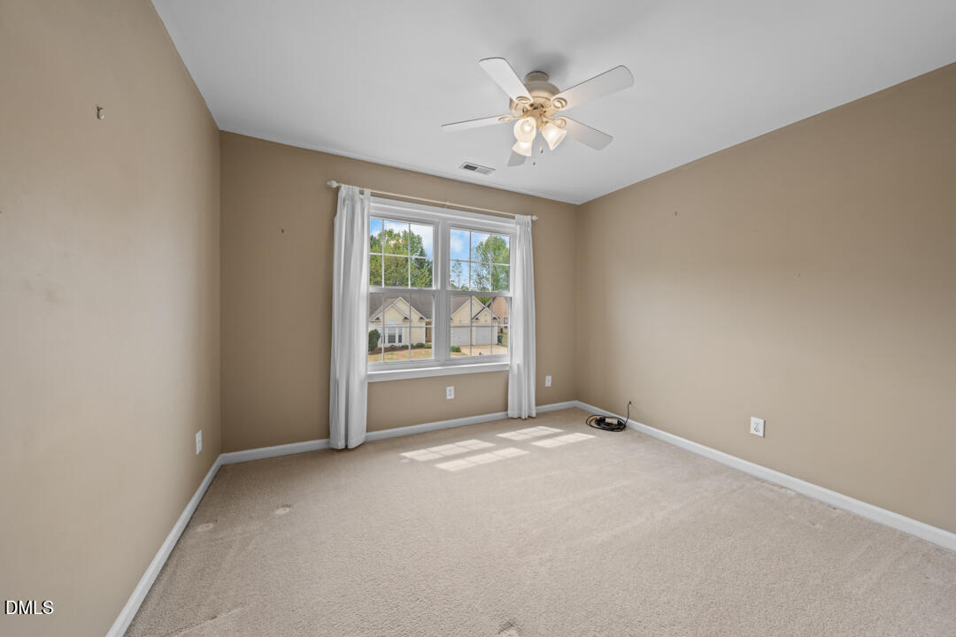 5324 Bartram Place Raleigh, NC 27617 - Photo 24 of 35 a view of an empty room with chandelier fan and fire place