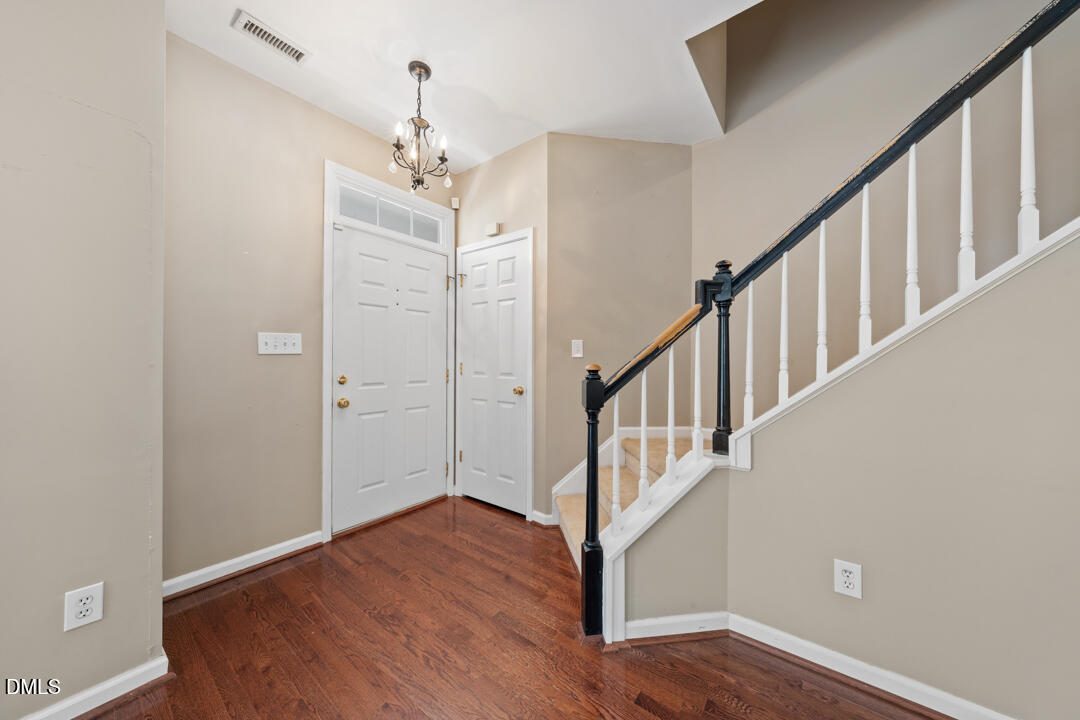 5324 Bartram Place Raleigh, NC 27617 - Photo 5 of 35 a view of a hallway with wooden floor and staircase