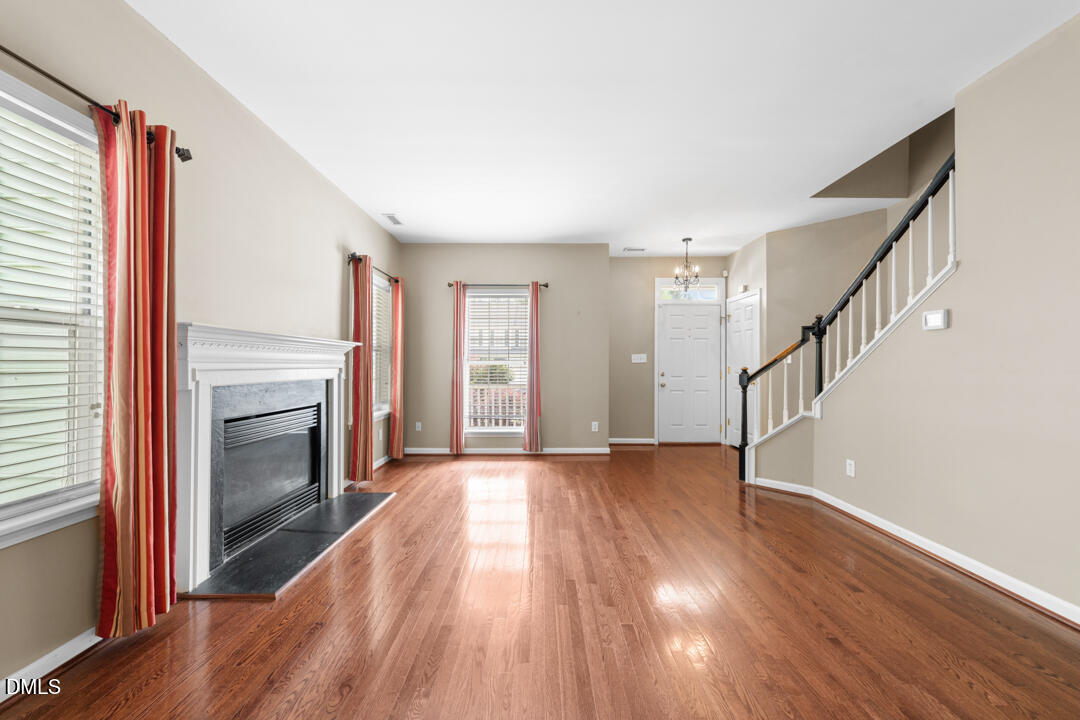 5324 Bartram Place Raleigh, NC 27617 - Photo 8 of 35 a view of an empty room with wooden floor fireplace and a window