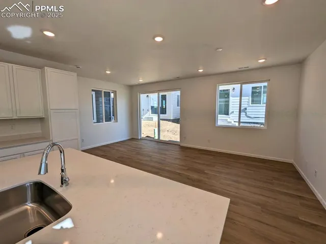 a view of a kitchen with a sink dishwasher and wooden floor
