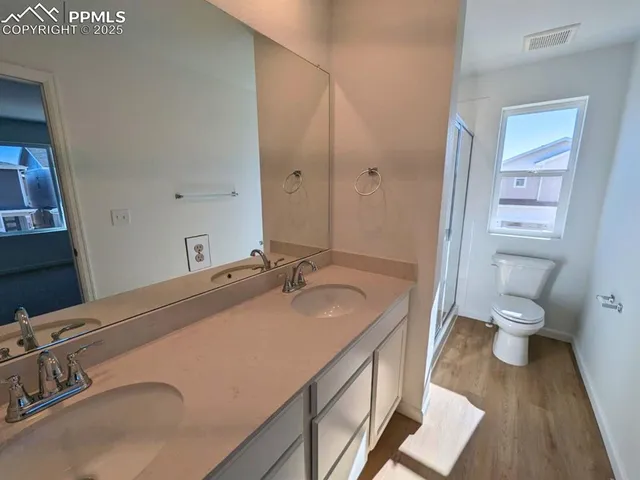 a bathroom with a granite countertop sink a toilet and a mirror
