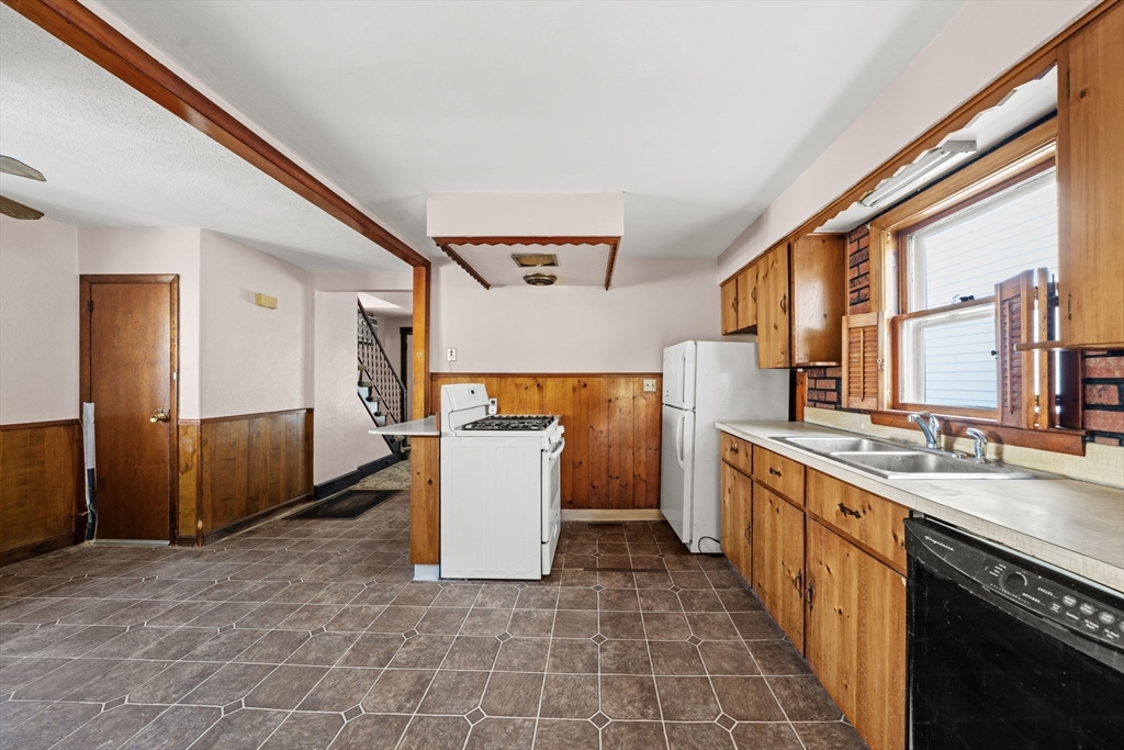6 Cottage Street Lowell, MA 01852 - Photo 14 of 32 a large kitchen with stainless steel appliances a sink and cabinets