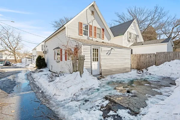 a view of a white house with a yard covered in snow