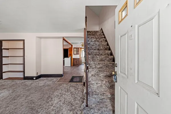a view of a livingroom with wooden floor and stairs
