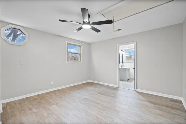 a view of empty room with wooden floor