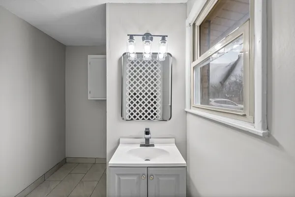 a bathroom with a sink mirror and window