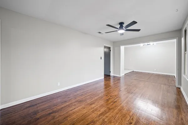 a view of an empty room with wooden floor