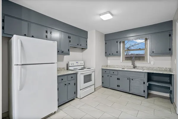 a kitchen with cabinets stainless steel appliances and a window