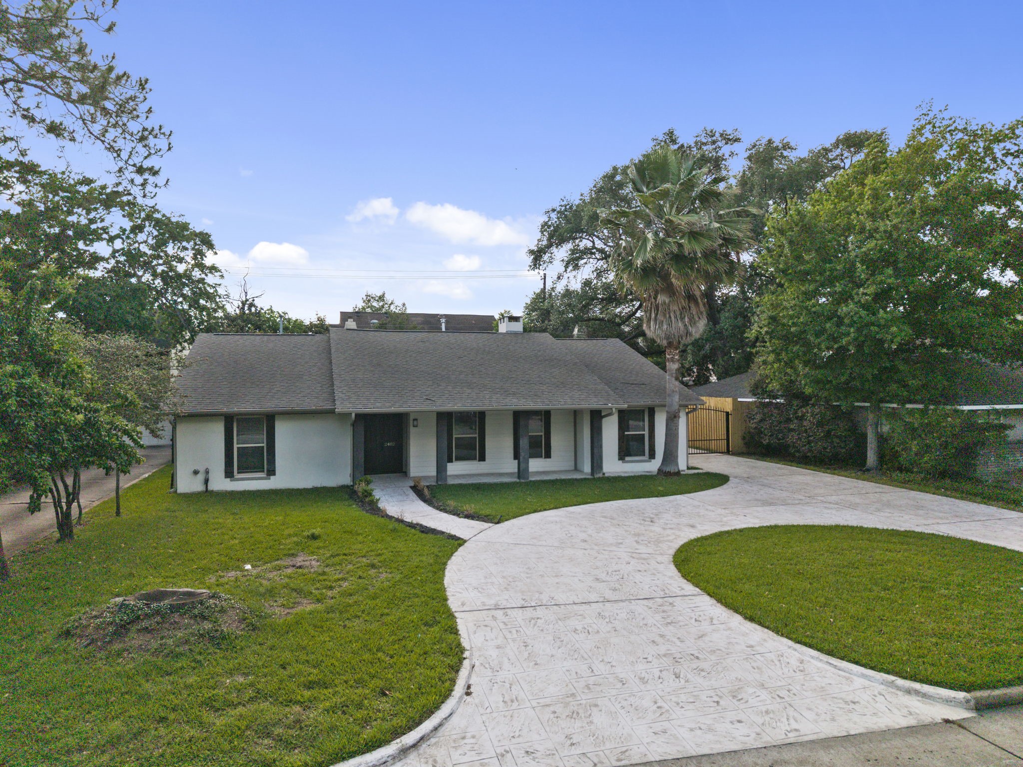 2402 Chimney Rock Road Houston, TX 77057 - Photo 2 of 36 Beautiful single-story home with strong curb appeal, featuring a sweeping curved driveway and inviting covered front porch.
