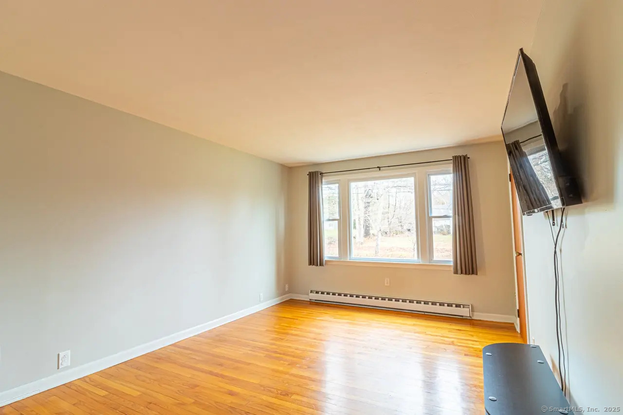 405 Noank Ledyard Road Groton, CT 06355 - Photo 16 of 17 a view of an empty room with wooden floor and a window