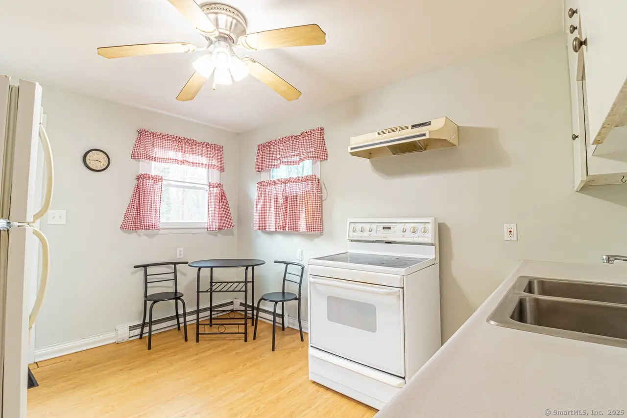 405 Noank Ledyard Road Groton, CT 06355 - Photo 9 of 17 a kitchen that has a stove and a table chair