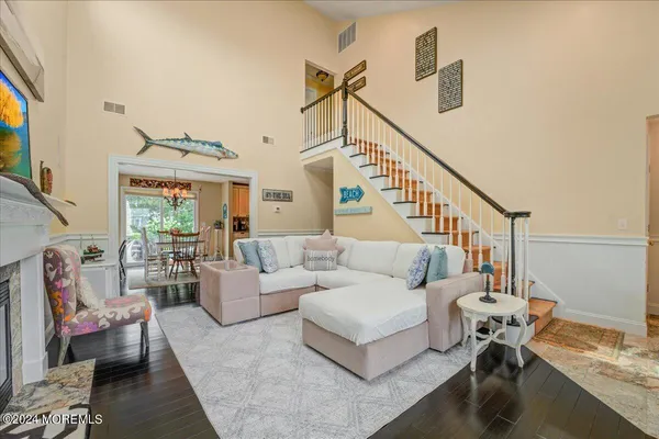 a living room with furniture and a dining table with wooden floor