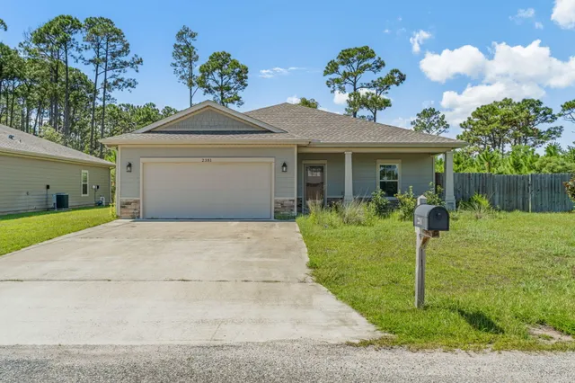 a front view of a house with a yard and a garage