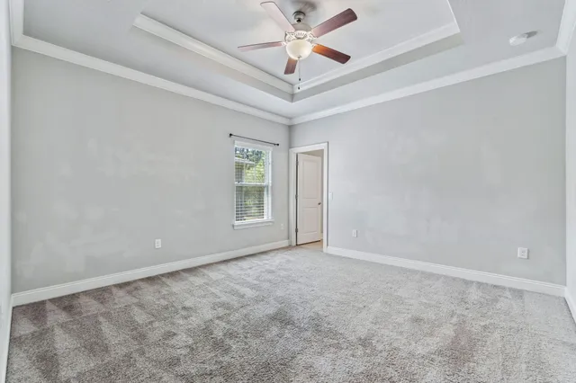 en empty room with windows and ceiling fan