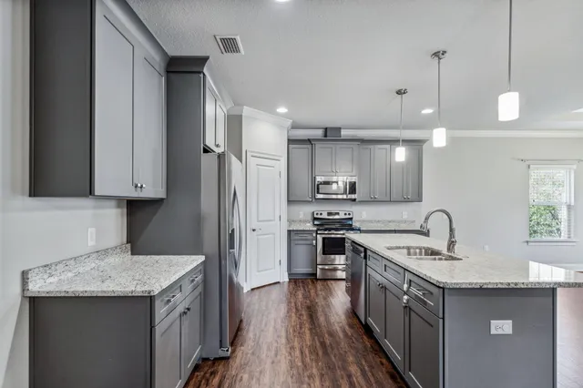 a kitchen with stainless steel appliances granite countertop a sink stove and refrigerator