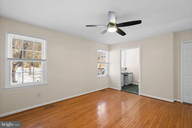 a view of an empty room with a window and fireplace