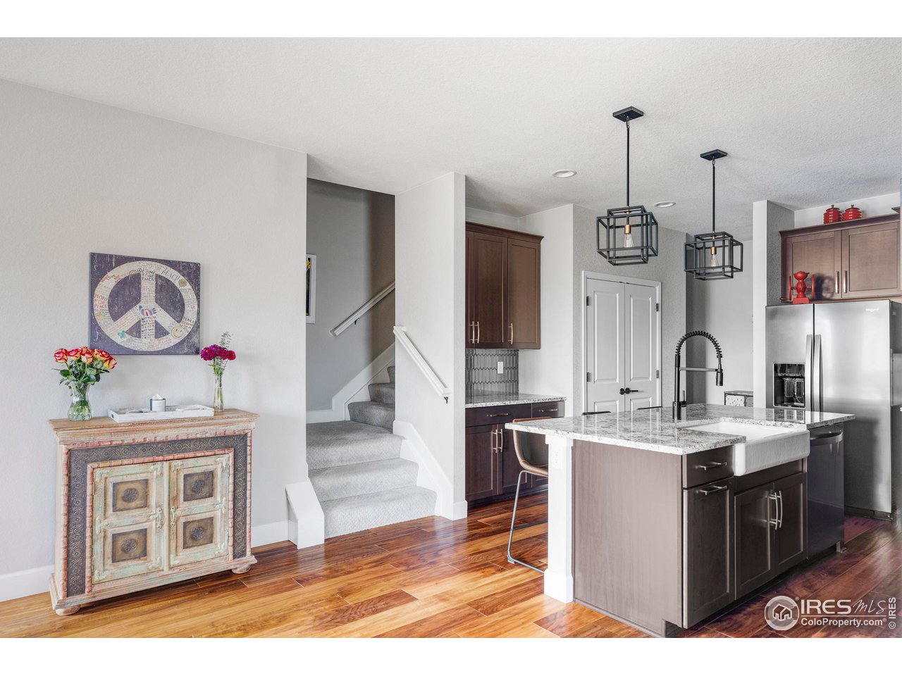 784 Stonebridge Drive Longmont, CO 80503 - Photo 35 of 35 a kitchen with stainless steel appliances granite countertop a stove a sink dishwasher and white cabinets with wooden floor