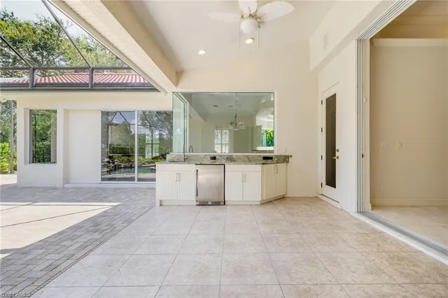 a view of a kitchen with kitchen island a sink hardwood floor and a large window