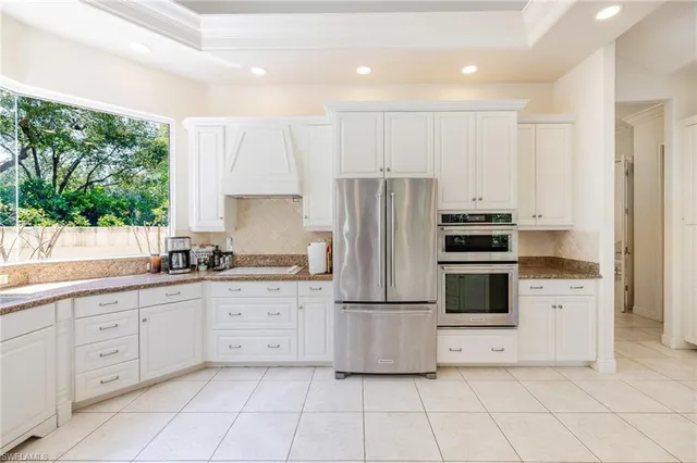 a kitchen with white cabinets a refrigerator and a stove