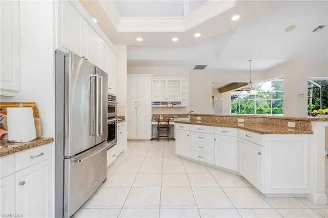 a large kitchen with stainless steel appliances granite countertop a refrigerator and a sink