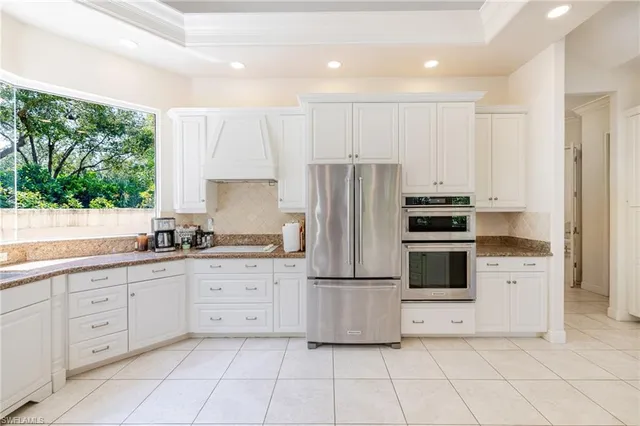 a kitchen with white cabinets a refrigerator and a stove